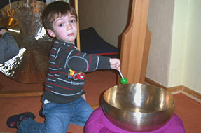 Bild zeigt Kind beim spielen mit einer Klangschale in der Kita Traumzauberland